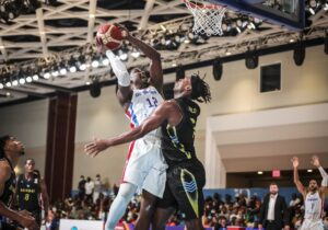 El dominicano Ángel Luis Delgado en una ofensiva sobre Buddy Hield, de Bahamas.