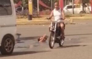 Mujer desafía el tránsito y se baña en cloaca de carretera Mella en SDE