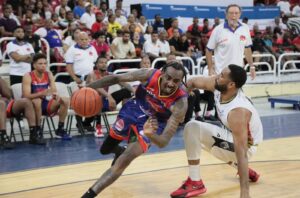 Timmy Bond de Reales de La Vega lleva la pelota frente a  la defensa de Juan Guerrero de Leones de Santo Domingo.