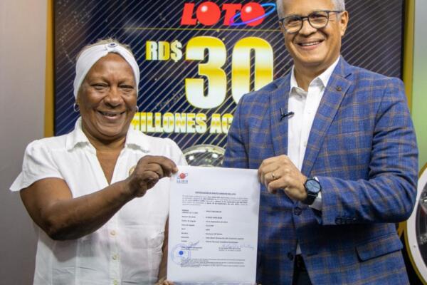 La ganadora de la Loto acompañada de Manuel Abreu, director de sorteo de la Loto. 
Foto: LEIDSA