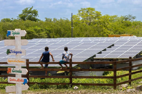 Niños al rededor de paneles solares.