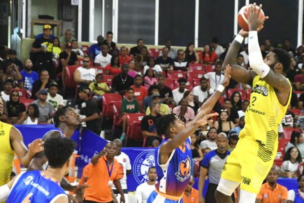 Branden Dawson, del club Rafael Barias, lanza hacia la canasta sobre la defensa de Anphernee Acevedo, de Huellas del Siglo.