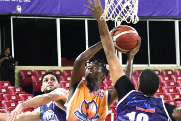 Michael Warren, de Huellas del Siglo, realiza una ofensiva entre los jugadores de El Millón, Bryan y Luis Del Orbe.