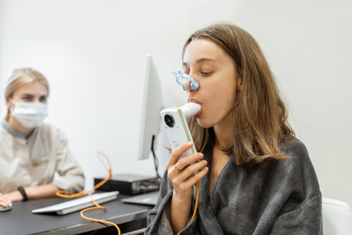 Joven realizandose un examen de espirometría