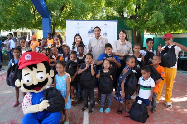 Sub director Eduardo Peña entregando útiles escolares a niños. Foto: Fuente externa. 