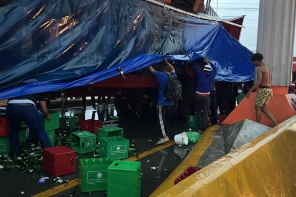 En la imagen varias personas tratando de sustraer las cajas de cervezas de camión volcado. Foto: CDN