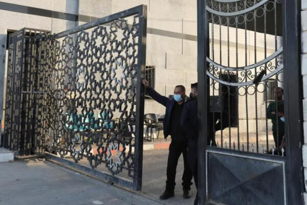 Los hombres se encuentran en una puerta mientras la gente se reúne en la frontera de Rafah, mientras se espera que los militantes de Hamás liberan a los rehenes secuestrados. / Fuente externa.