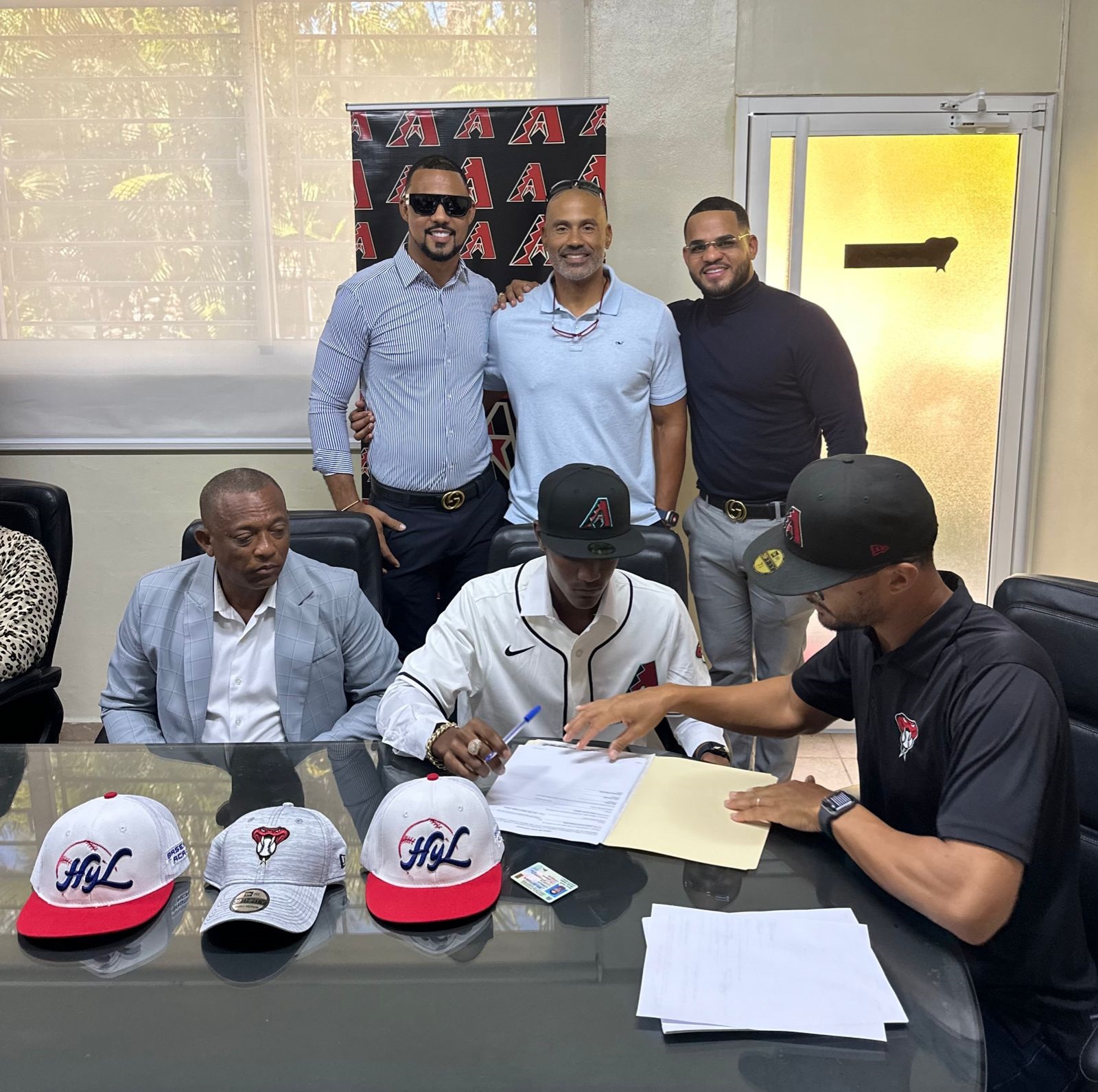 Durante la firma de prospecto Oscar Aponte por Arizona. Detrás directivos de H Y L Baseball Academy