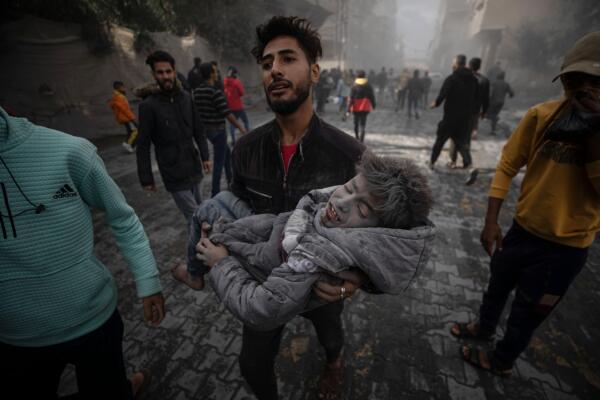Un hombre lleva a un niño herido tras los ataques aéreos de Israel en la ciudad de Rafah. Foto: fuente externa.