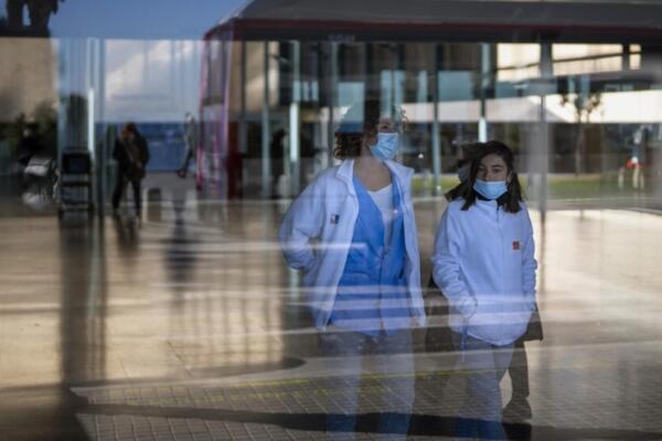 Personas con mascarillas como medida de precaución caminan por el interior de un hospital en Barcelona, España. Foto: fuente externa.