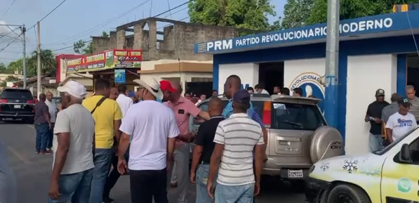 Hombres parados frente a casa del PRM en Sánchez Ramíre 