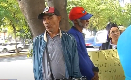 Empleados del INESPRE encadenados en un árbol de la institución. Foto; fuente externa. 