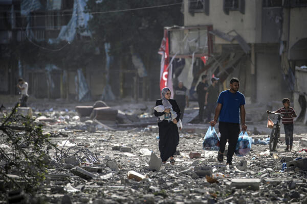 Una familia palestina entre los escombros de los edificios alcanzados en un bombardeo israelí sobre el barrio de Tel al-Hawa, en Gaza. Foto: fuente externa. 