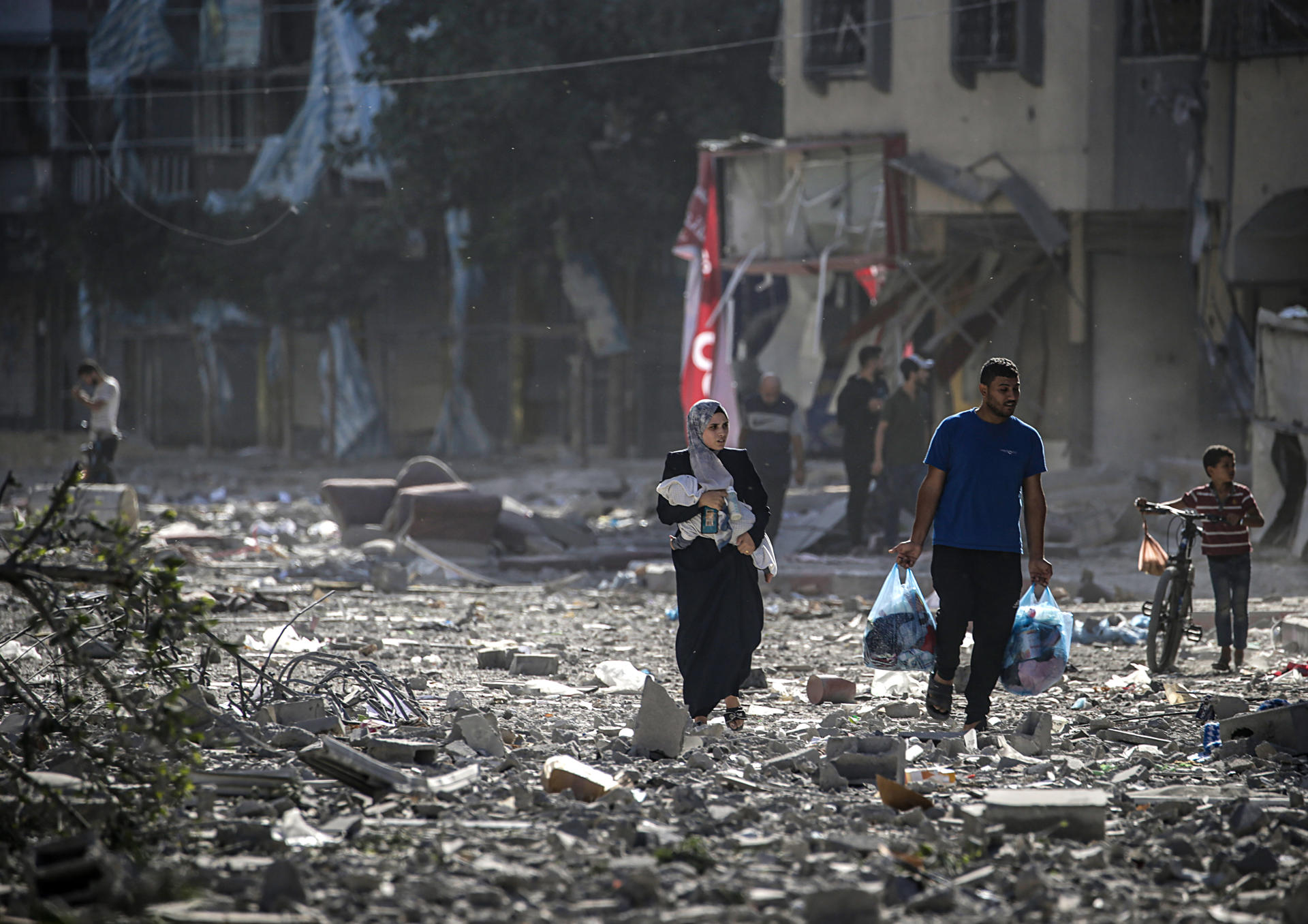 Una familia palestina entre los escombros de los edificios alcanzados en un bombardeo israelí sobre el barrio de Tel al-Hawa, en Gaza. Foto: fuente externa.