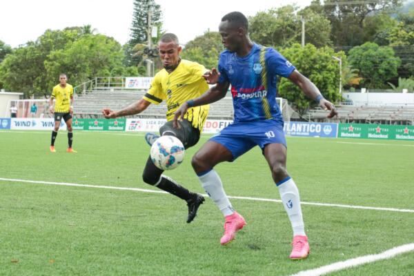 Carlos Rossel de Moca FC batalla en busca de la peltoa con Walny Bien-aimé de Atlántico FC