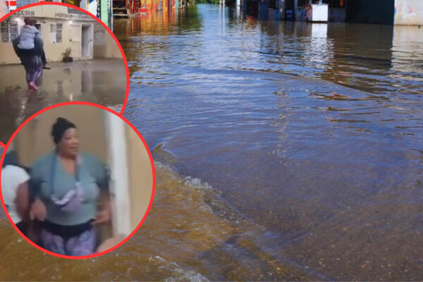 Una conserje carga a las maestras de una escuela inundada en Cotuí. Foto: CDN Digital 