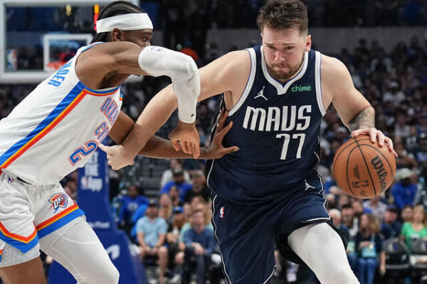 Luka Doncic de Dallas maneja la pelota ante la defensa de Shai-Gilgous Alexander de Oklahoma