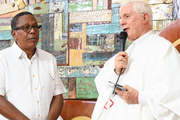 El reverendo padre Gregorio Alegría, haciendo la entrega del reconocimiento al director general de CEED. Foto: Fuente externa