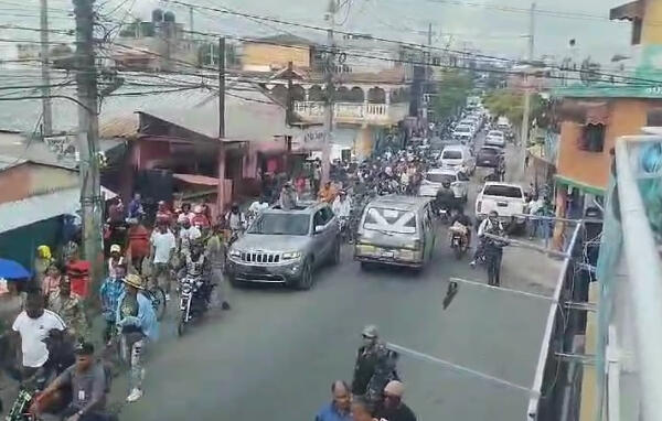 Ciudadanos mientras recorren las calles en forma de protesta en Los Alcarrizos. (Foto: fuente interna)