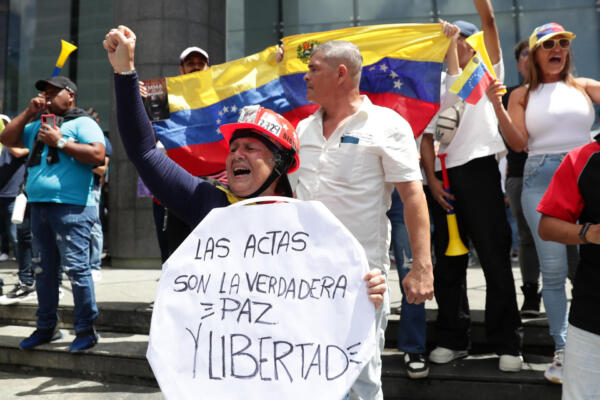 Una mujer sostiene un cartel este martes, durante una protesta contra los resultados dados por el CNE, en Caracas (Venezuela)