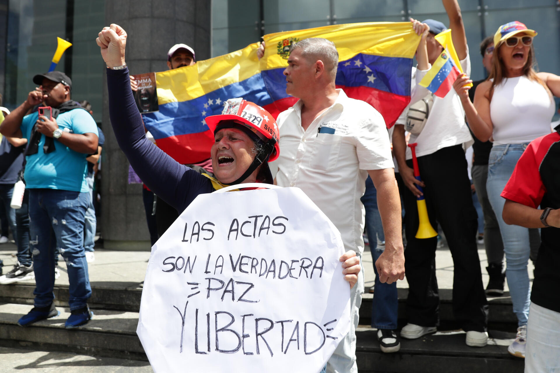 Una mujer sostiene un cartel este martes, durante una protesta contra los resultados dados por el CNE, en Caracas (Venezuela)