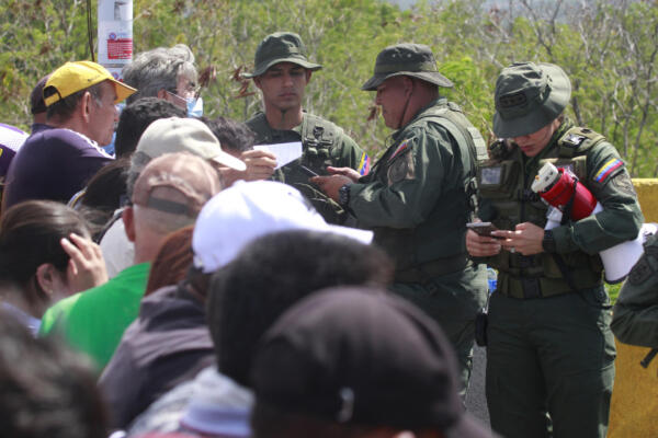 Integrantes de la Guardia Bolivariana de Venezuela revisan los documentos de venezolanos que intentan ingresar a su país