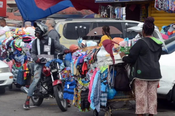 Choferes de concho, motoconchistas, y vendedores se disputan puestos en acera, calle y áreas verdes para operar sus negocios