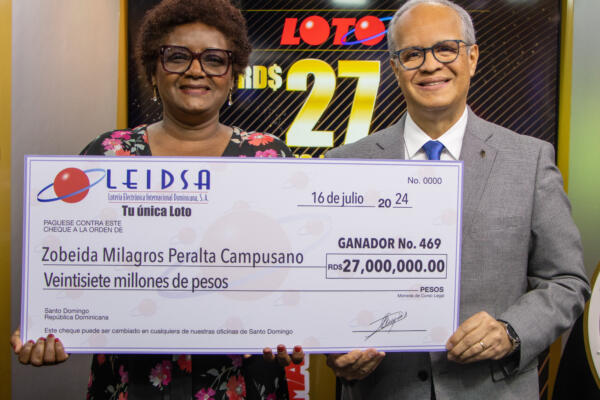 Dra. Zobeida Milagros Peralta Campusano, recibe cheque de la mano del Lic. Manuel Abreu, director de sorteos de Leidsa 