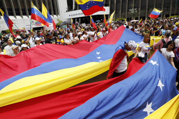 Personas sostienen banderas durante una manifestación en apoyo a los venezolanos tras elecciones, este miércoles en la plazoleta del Centro Administrativo La Alpujarra, en Medellín (Colombia). EFE/ Luis Eduardo Noriega Arboleda