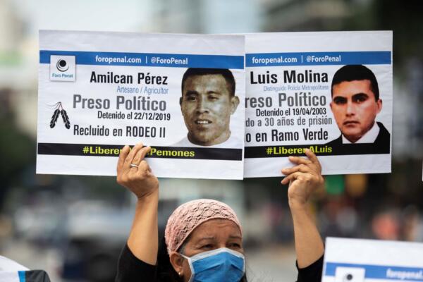 Fotografía de archivo del 10 de diciembre de 2020 de una mujer se manifiesta con carteles exigiendo el respeto de los derechos humanos en Caracas