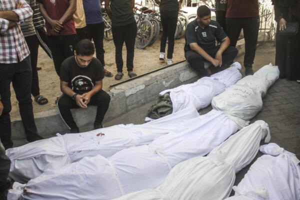Un grupo de palestinos en duelo ante cadáveres de víctimas del bombardeo israelí de una escuela en Gaza.