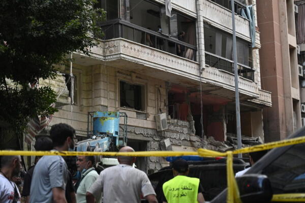 La gente se reúne frente a un edificio dañado después de un ataque militar israelí, en Beirut, Líbano