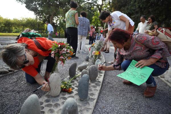 Familiares de víctimas y organizaciones sociales de Perú que participan en una jornada de ofrenda en el memorial El ojo que llora. EFE