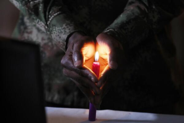 Fotografía de archivo del 31 de marzo de 2023 de un soldado que protege una vela encendida durante una 'velatón' en memoria de los soldados asesinados en el marco del conflicto en el país, en Bogotá (Colombia). 
