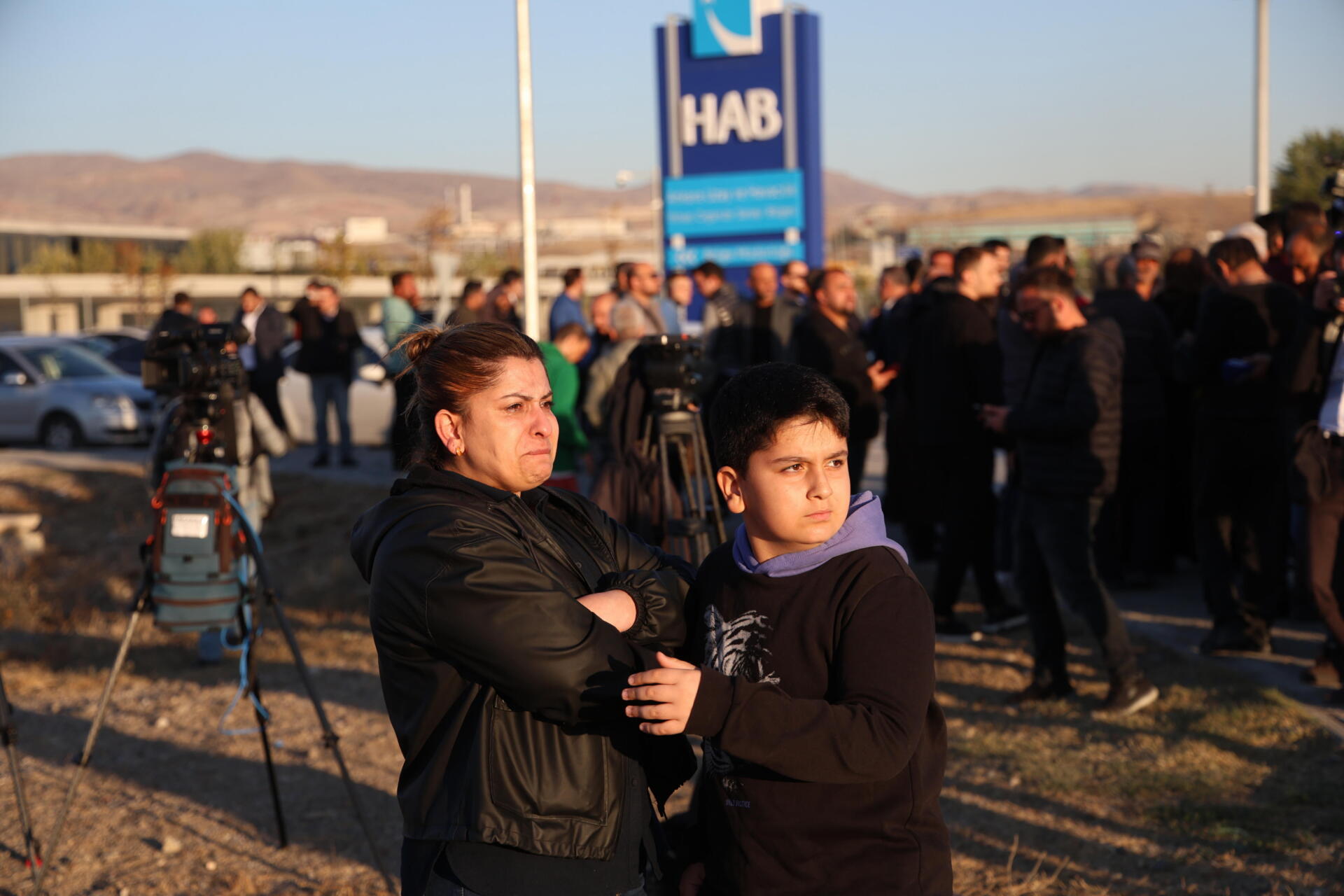 Familiares de empleados esperan afuera luego de un ataque terrorista en la sede del Centro Turco Aeroespacial y de Aviación (TUSAS) en Ankara, Turquía