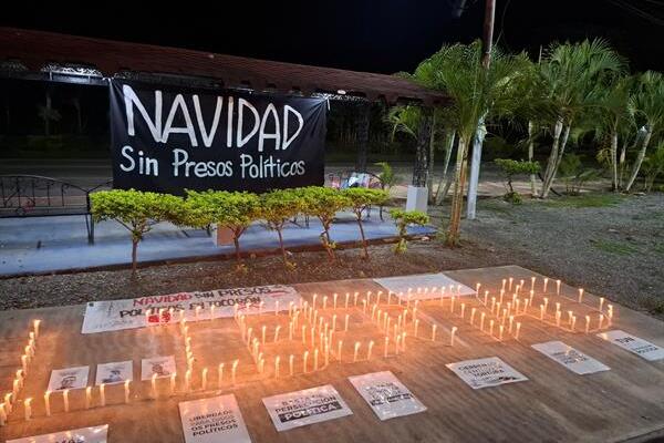 Fotografía cedida por el Comité por la Libertad de los Presos Políticos de velas encendidas por familiares de privados de libertad en una manifestación este jueve