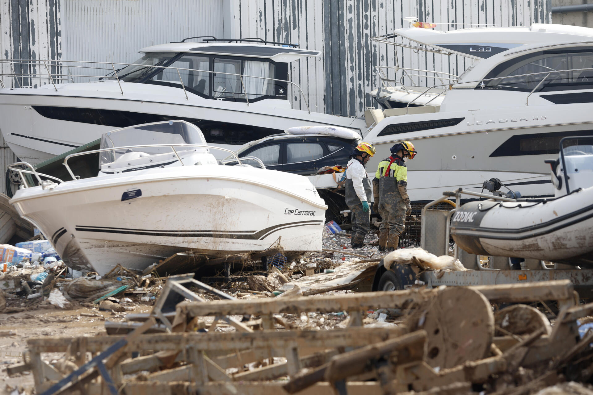Dos bomberos inspeccionan las inmediaciones de una empresa con lanchas marinas en Massanassa, este miércoles.