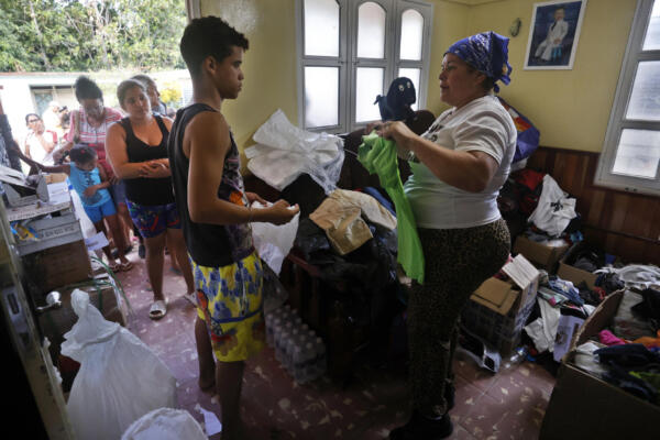 Una mujer entrega donaciones a afectados por el paso de la tormenta tropical Óscar