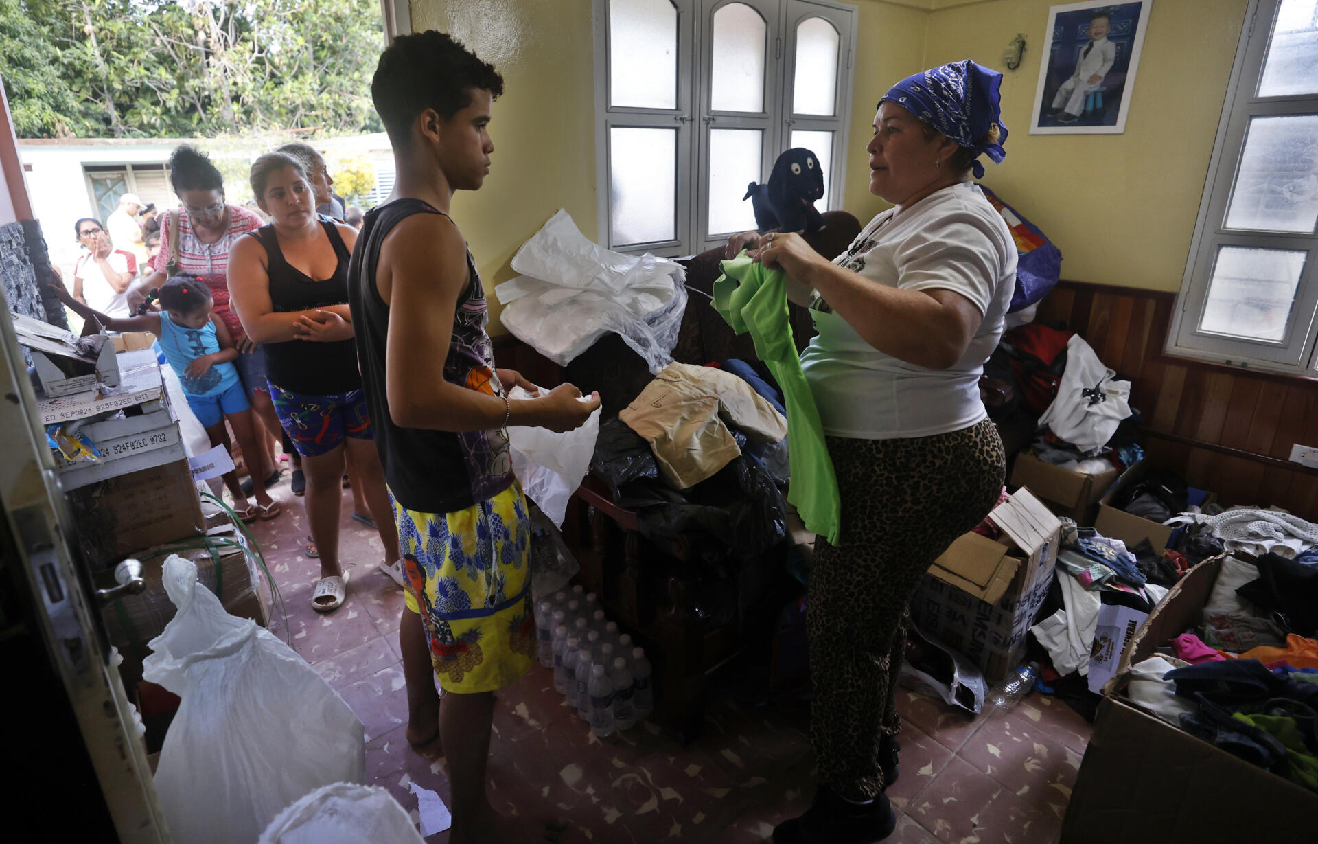 Una mujer entrega donaciones a afectados por el paso de la tormenta tropical Óscar