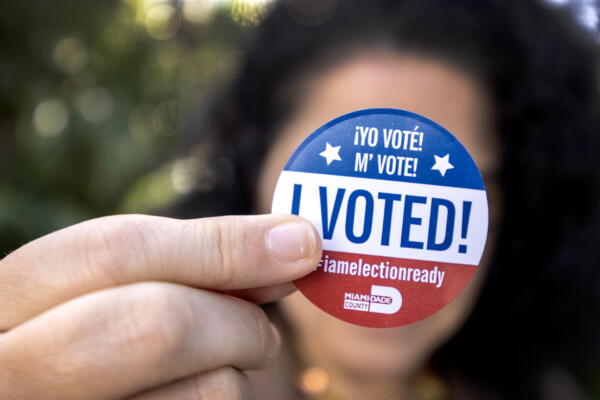Persona muestra una calcomanía de Yo voté en la votación anticipada en Miami, Florida. EFE