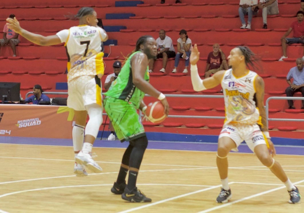 Roddy Ramírez, del club Laguneros de Madre Vieja Norte, busca pasar el balón entre dos jugadores de Pueblo Nuevo.