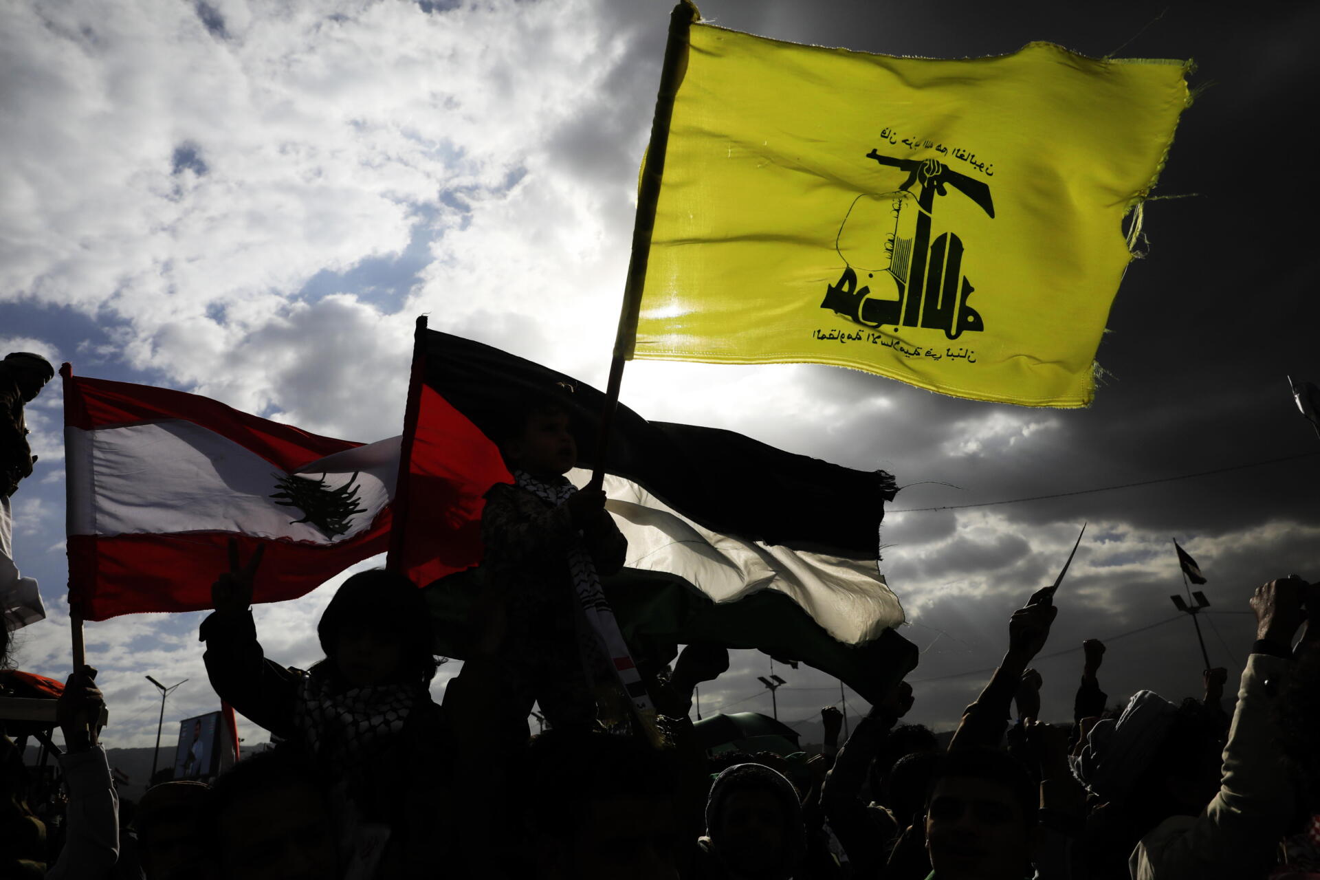Los simpatizantes de los hutíes agitan las banderas de (de dcha. a izq.) Hezbolá, Palestina y Líbano durante una protesta contra Estados Unidos