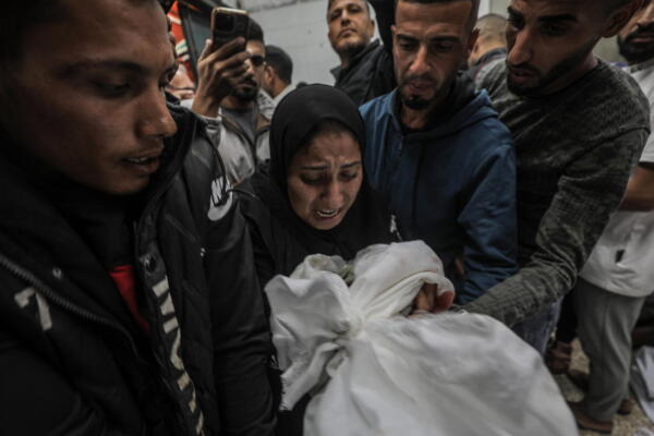 Mujer lleva el cuerpo de un niño en el hospital en el centro de la Franja de Gaza. EFE