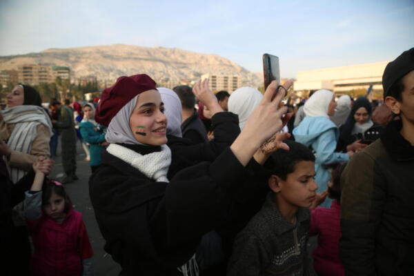 Cientos de personas celebran el derrocamiento del presidente sirio al-Assad, en la plaza Omeya de Damasco, Siria