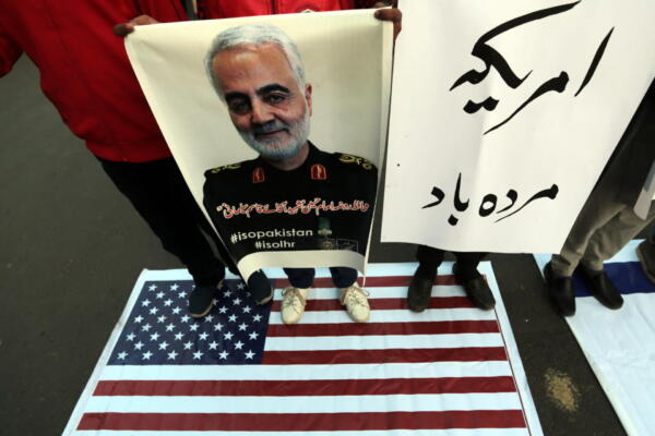 Fotografía de archivo del 3 de enero de 20202 de musulmanes chiítas paquistaníes que sostienen imágenes del general Qasem Soleimani
