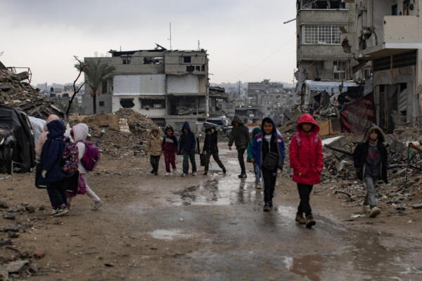 Niños palestinos caminan por las calles de la ciudad de Yan Yunis, en el sur de la Franja de Gaza, muy dañada por las fuertes lluvias caídas.