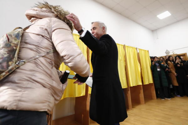 El ganador de la primera vuelta de las presidenciales, el prorruso Calin Georgescu, saluda a una simpatizante