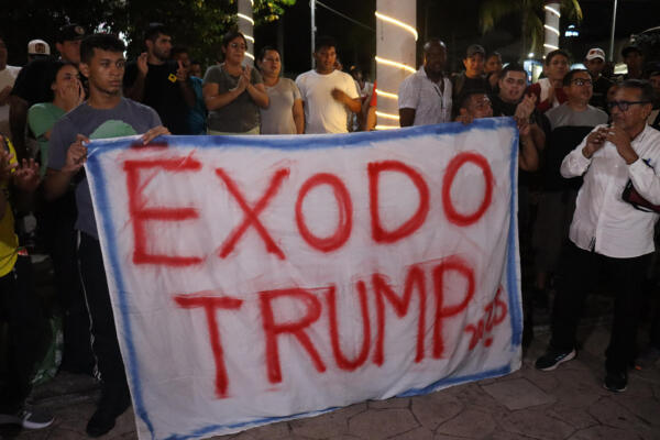 Migrantes sostienen una pancarta al iniciar una caravana que se dirige a la frontera norte de México este domingo, en el municipio de Tapachula en Chiapas (México)