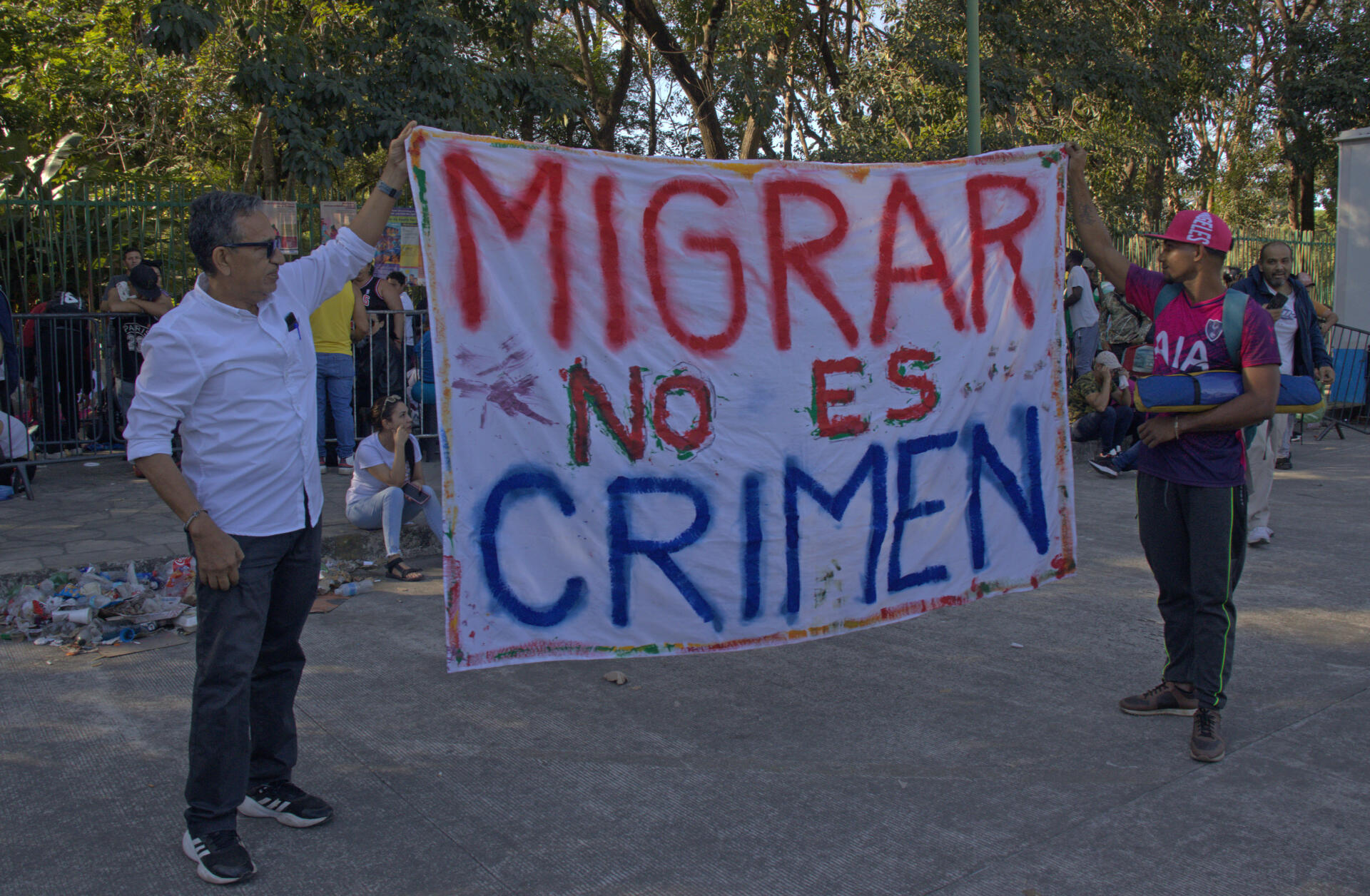 Fotografía de archivo en donde se ven migrantes que sostienen un cartel.