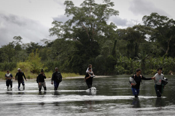 Migrantes que cruzan el río Tuquesa luego de atravesar la selva del Darién, frontera natural entre Colombia y Panamá. 
EFE/ Bienvenido Velasco